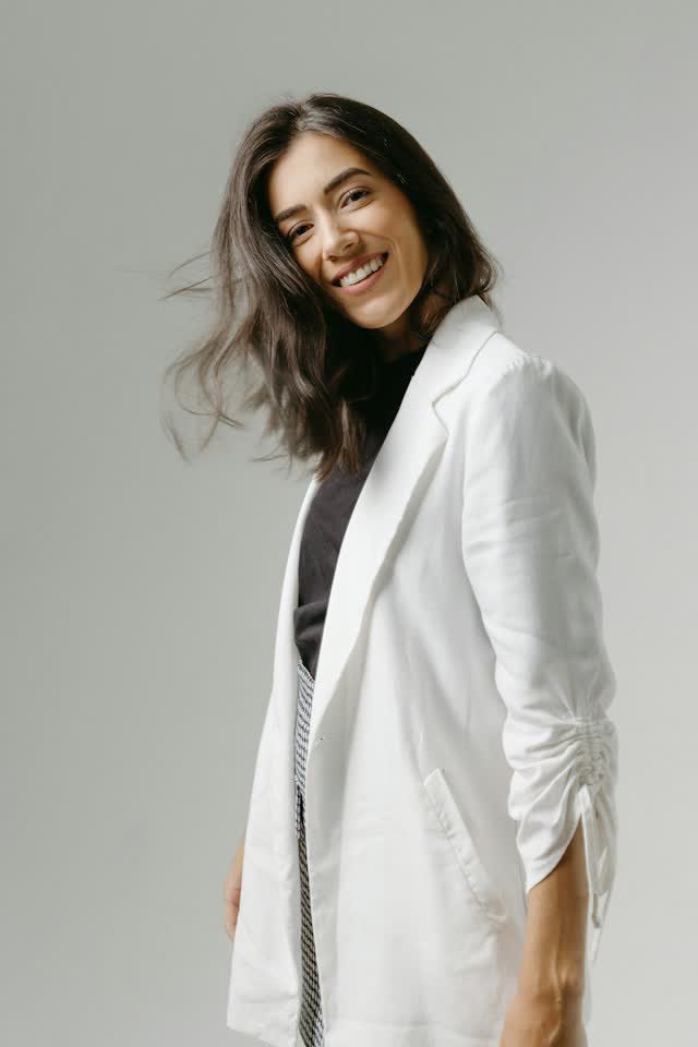 Dra. Lívia Montenaro de blazer branco, sorrindo