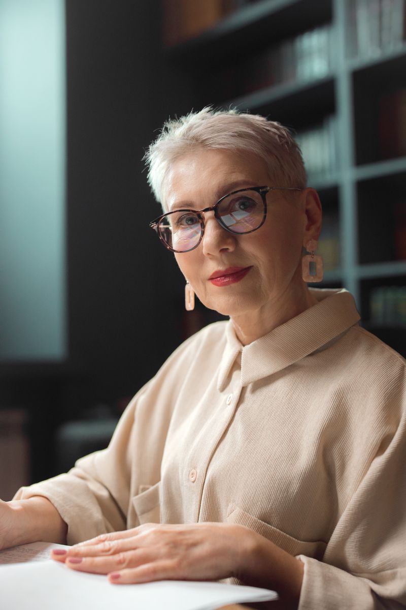 Dra. Celina Varonesi, geriatra, de óculos e camisa bege, à mesa