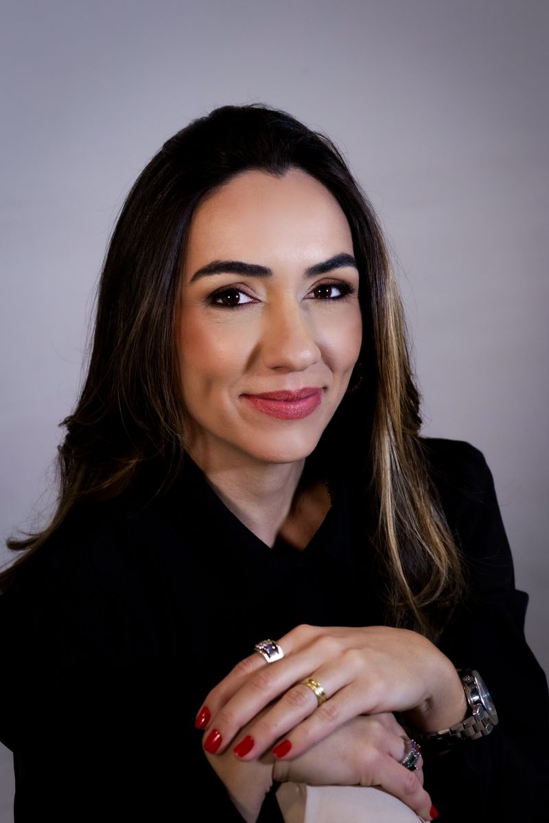Dra. Renata Valdisser, ginecologista, de blusa preta, sorrindo